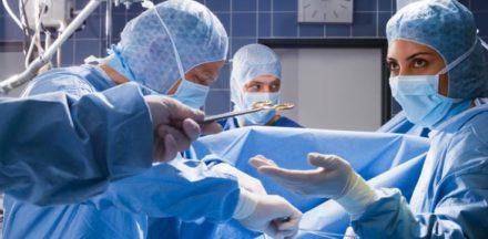 Surgical Assistant Handing Forceps to Surgeon --- Image by © Heide Benser/Corbis